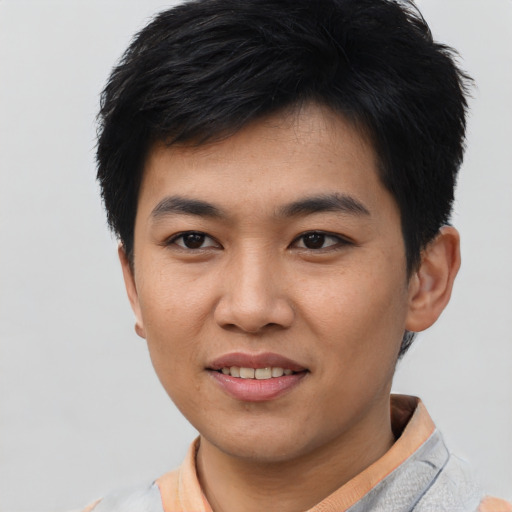 Joyful asian young-adult male with short  black hair and brown eyes