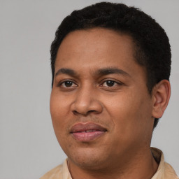 Joyful latino young-adult male with short  black hair and brown eyes