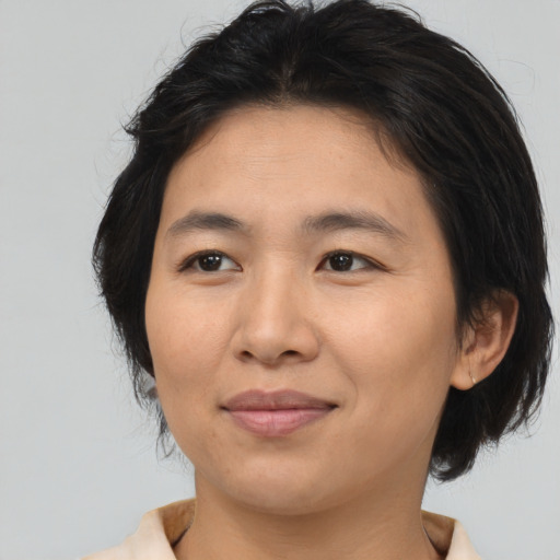 Joyful asian adult female with medium  brown hair and brown eyes