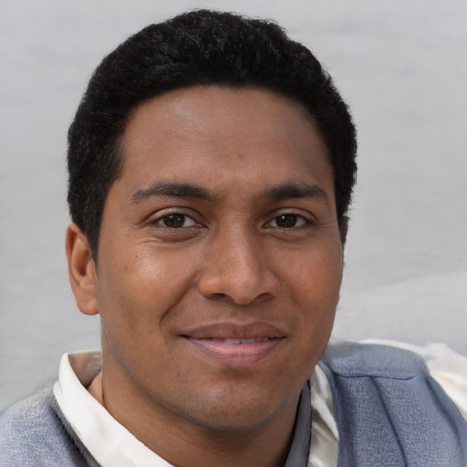 Joyful black young-adult male with short  brown hair and brown eyes