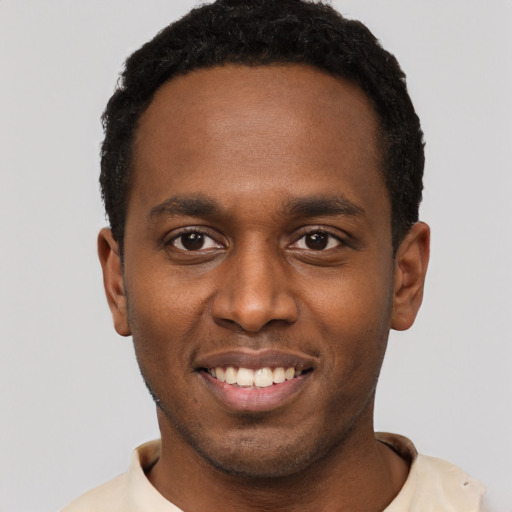 Joyful black young-adult male with short  black hair and brown eyes