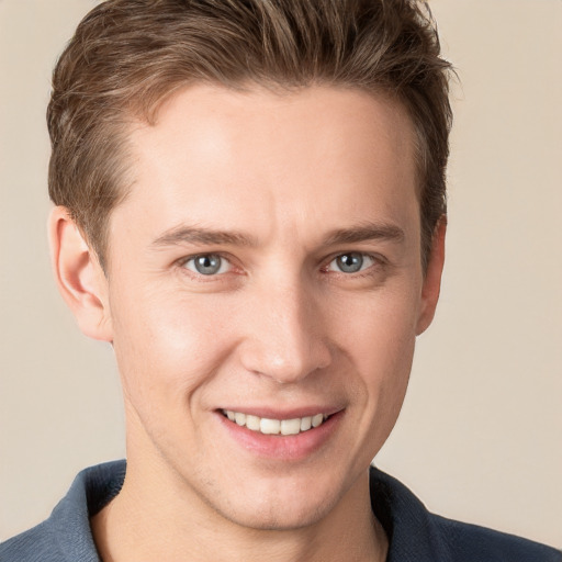 Joyful white young-adult male with short  brown hair and grey eyes