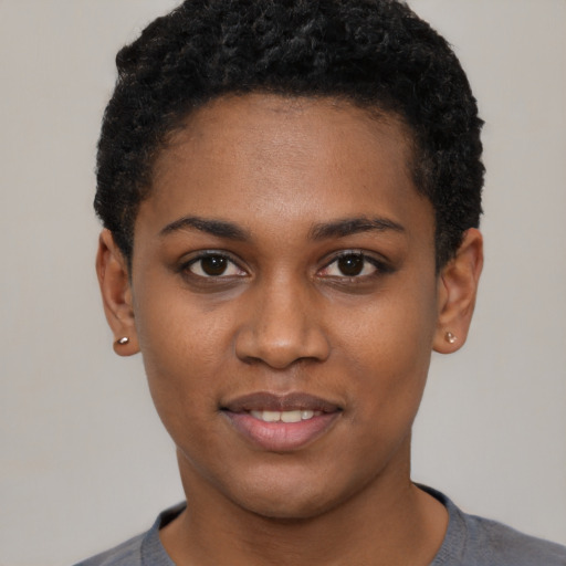 Joyful black young-adult female with short  black hair and brown eyes