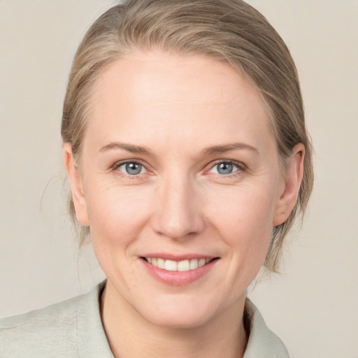 Joyful white adult female with medium  brown hair and blue eyes