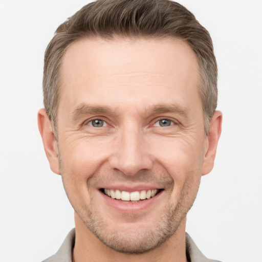 Joyful white adult male with short  brown hair and grey eyes