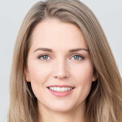 Joyful white young-adult female with long  brown hair and grey eyes