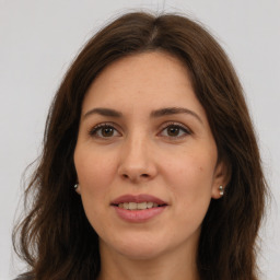 Joyful white adult female with long  brown hair and brown eyes