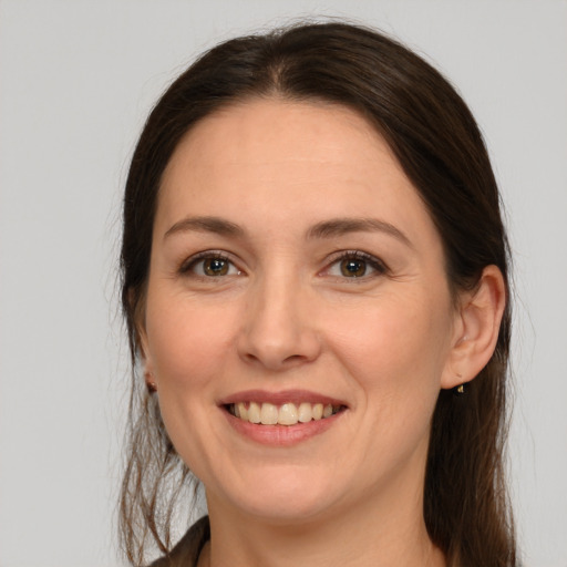 Joyful white young-adult female with long  brown hair and brown eyes