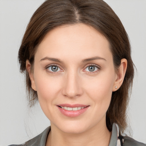 Joyful white young-adult female with medium  brown hair and grey eyes