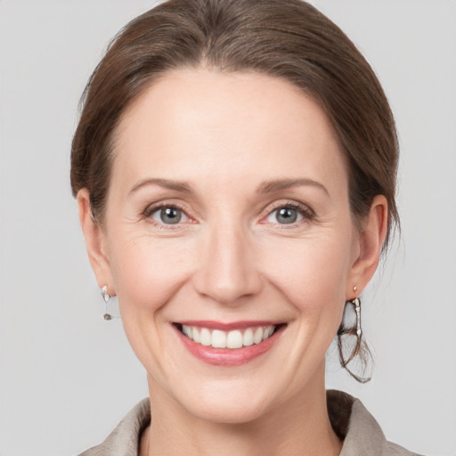 Joyful white adult female with medium  brown hair and grey eyes