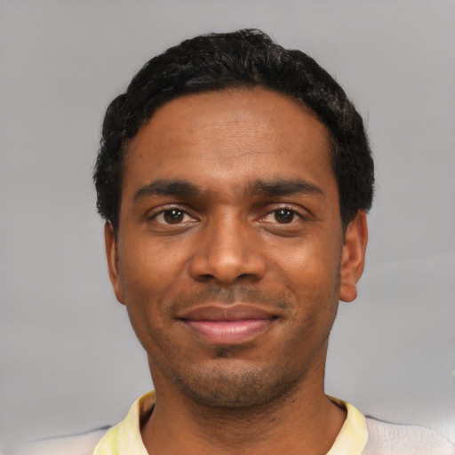 Joyful black young-adult male with short  black hair and brown eyes