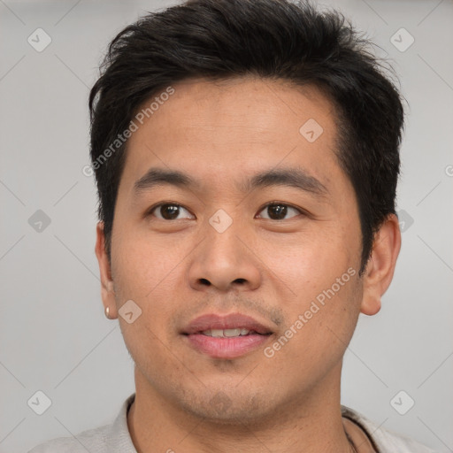 Joyful asian young-adult male with short  brown hair and brown eyes