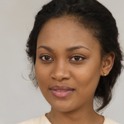 Joyful black young-adult female with medium  brown hair and brown eyes