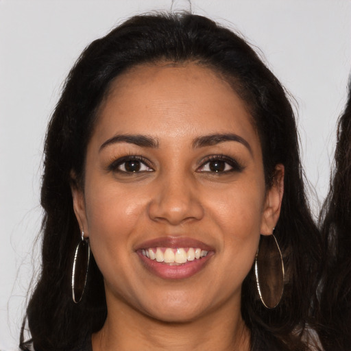 Joyful latino young-adult female with long  brown hair and brown eyes