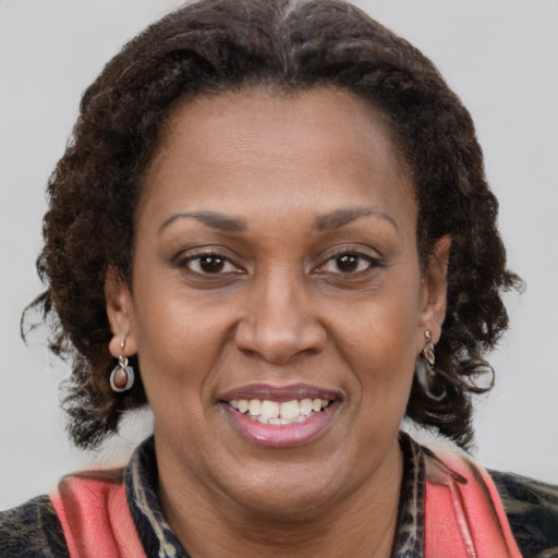 Joyful black adult female with medium  brown hair and brown eyes