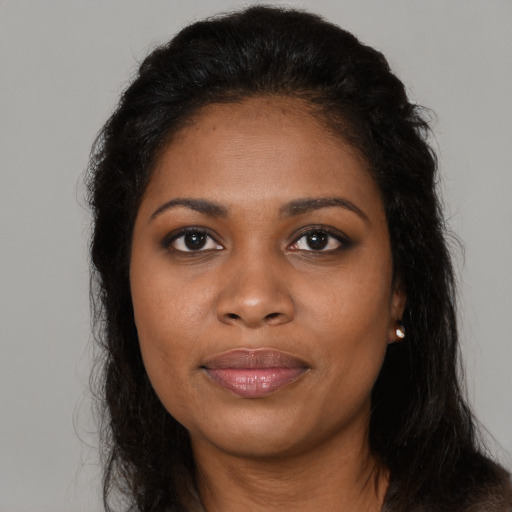 Joyful black young-adult female with long  brown hair and brown eyes