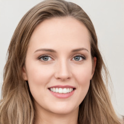 Joyful white young-adult female with long  brown hair and green eyes