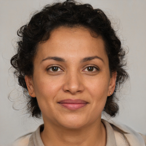 Joyful latino adult female with medium  brown hair and brown eyes