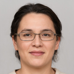 Joyful white adult female with medium  brown hair and grey eyes