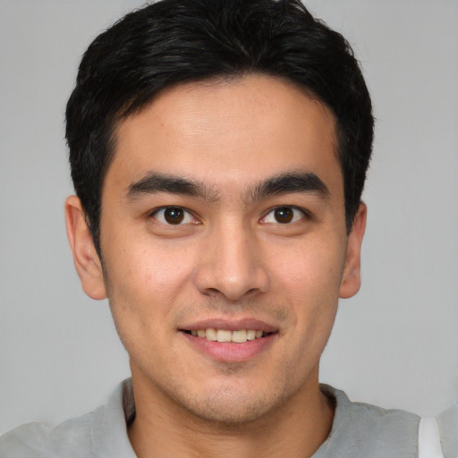 Joyful latino young-adult male with short  brown hair and brown eyes