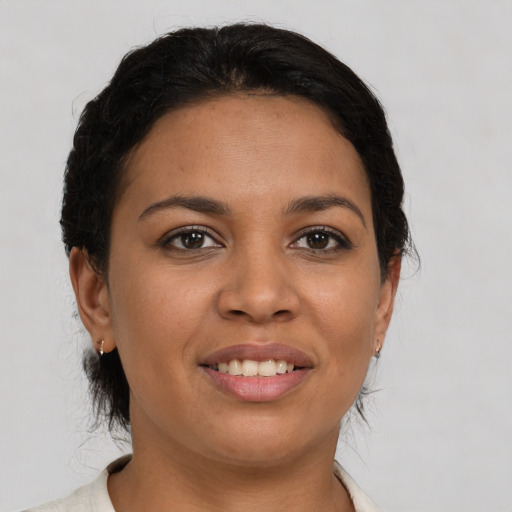 Joyful latino young-adult female with short  brown hair and brown eyes