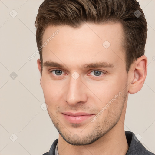 Joyful white young-adult male with short  brown hair and grey eyes