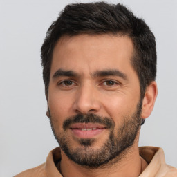 Joyful latino adult male with short  black hair and brown eyes