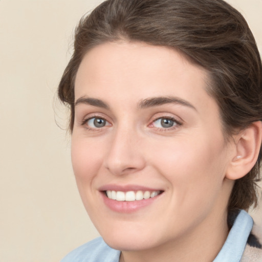 Joyful white young-adult female with medium  brown hair and green eyes