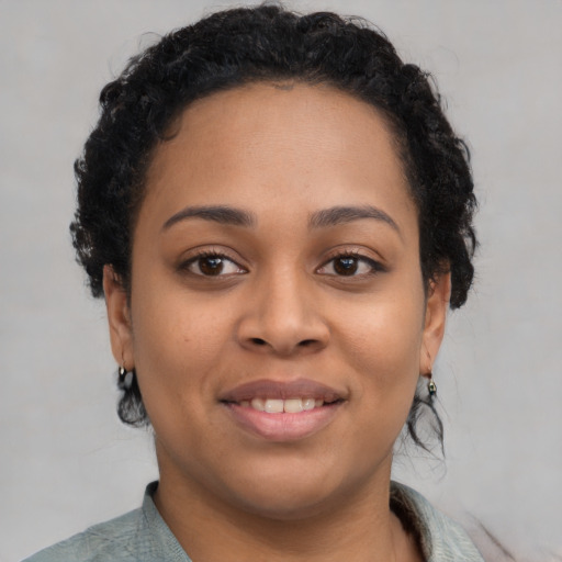 Joyful black young-adult female with short  brown hair and brown eyes