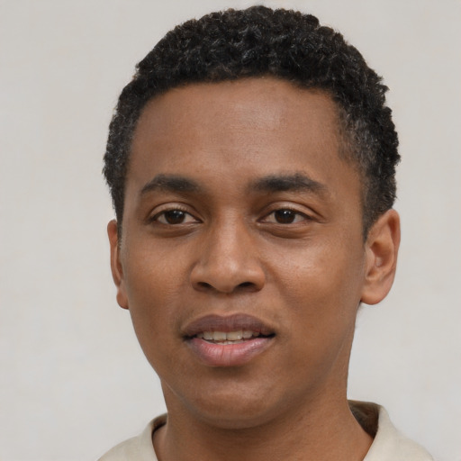 Joyful black young-adult male with short  black hair and brown eyes