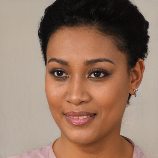 Joyful black young-adult female with short  black hair and brown eyes