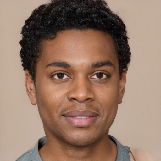 Joyful black young-adult male with short  black hair and brown eyes