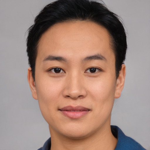 Joyful asian young-adult male with short  black hair and brown eyes