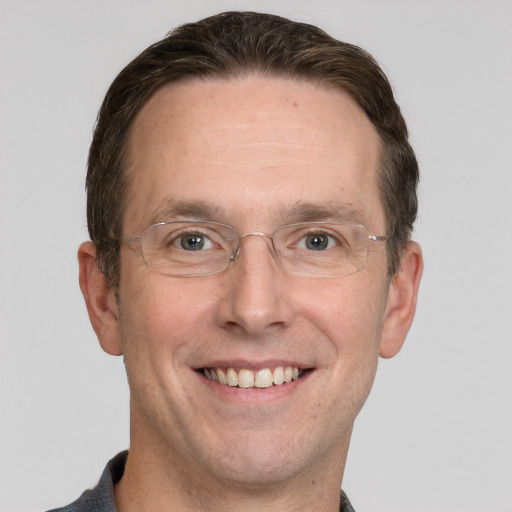 Joyful white adult male with short  brown hair and grey eyes