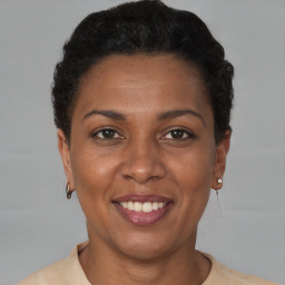 Joyful black adult female with short  brown hair and brown eyes