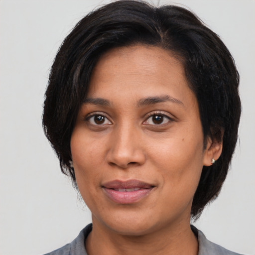 Joyful latino adult female with medium  brown hair and brown eyes