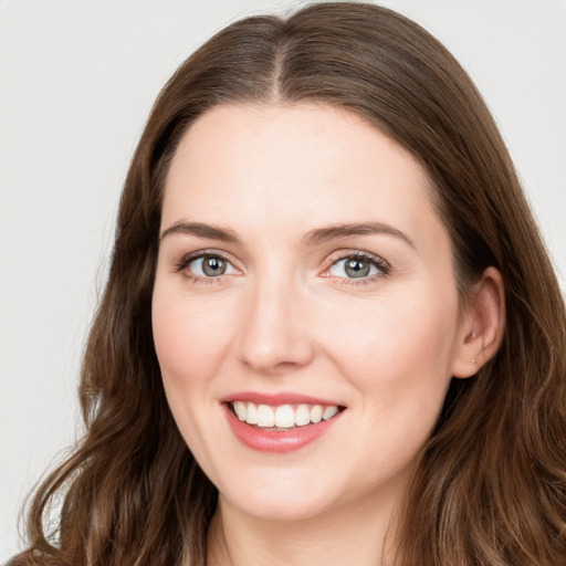 Joyful white young-adult female with long  brown hair and green eyes