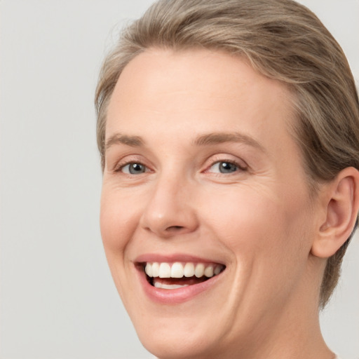 Joyful white adult female with medium  brown hair and blue eyes