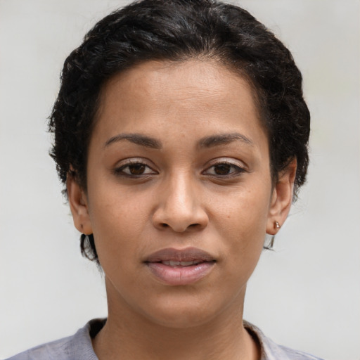 Joyful latino young-adult female with short  black hair and brown eyes