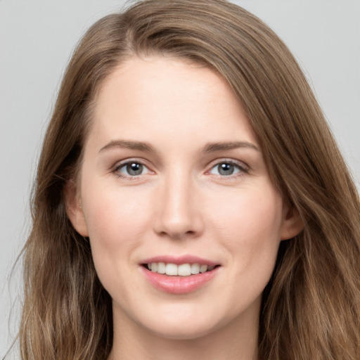 Joyful white young-adult female with long  brown hair and grey eyes