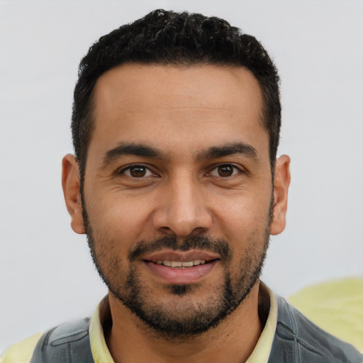 Joyful latino young-adult male with short  black hair and brown eyes