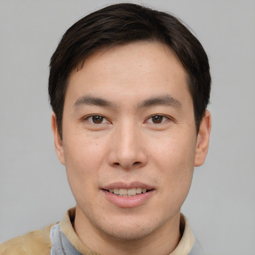 Joyful asian young-adult male with short  brown hair and brown eyes