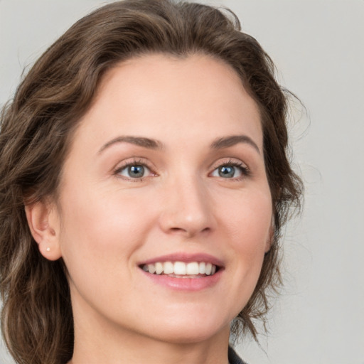 Joyful white young-adult female with medium  brown hair and green eyes