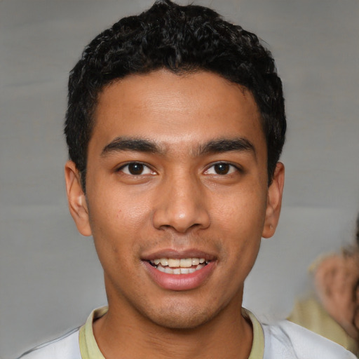 Joyful latino young-adult male with short  black hair and brown eyes
