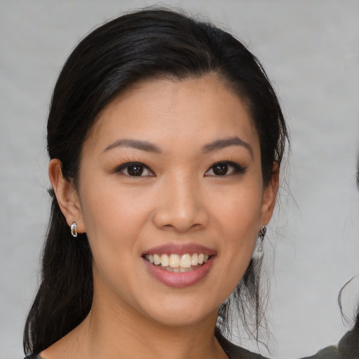 Joyful asian young-adult female with medium  brown hair and brown eyes