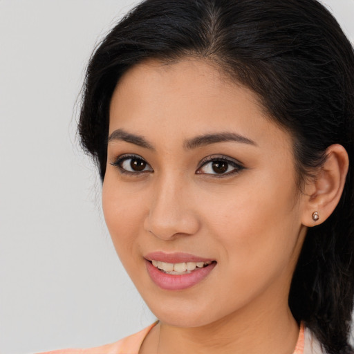 Joyful latino young-adult female with long  brown hair and brown eyes