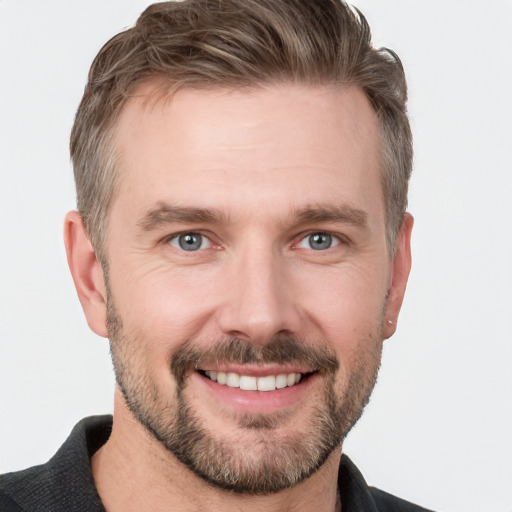 Joyful white young-adult male with short  brown hair and grey eyes