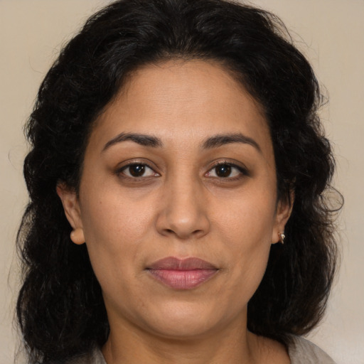 Joyful latino adult female with medium  brown hair and brown eyes