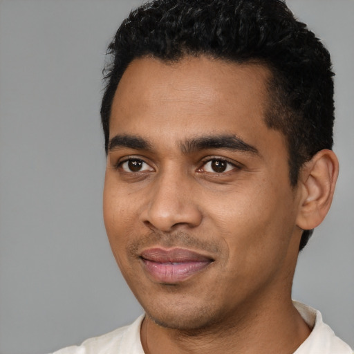 Joyful latino young-adult male with short  black hair and brown eyes