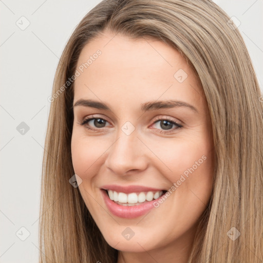 Joyful white young-adult female with long  brown hair and brown eyes